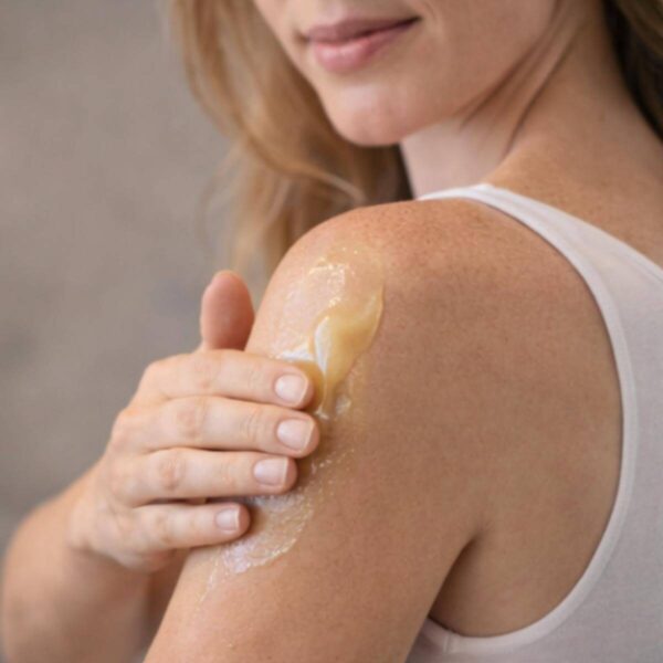 Tallow honingzalf aanbrengen schouder vrouw gouden kleur bio-identiek rauwe honing healing balm droge huid natuurlijk